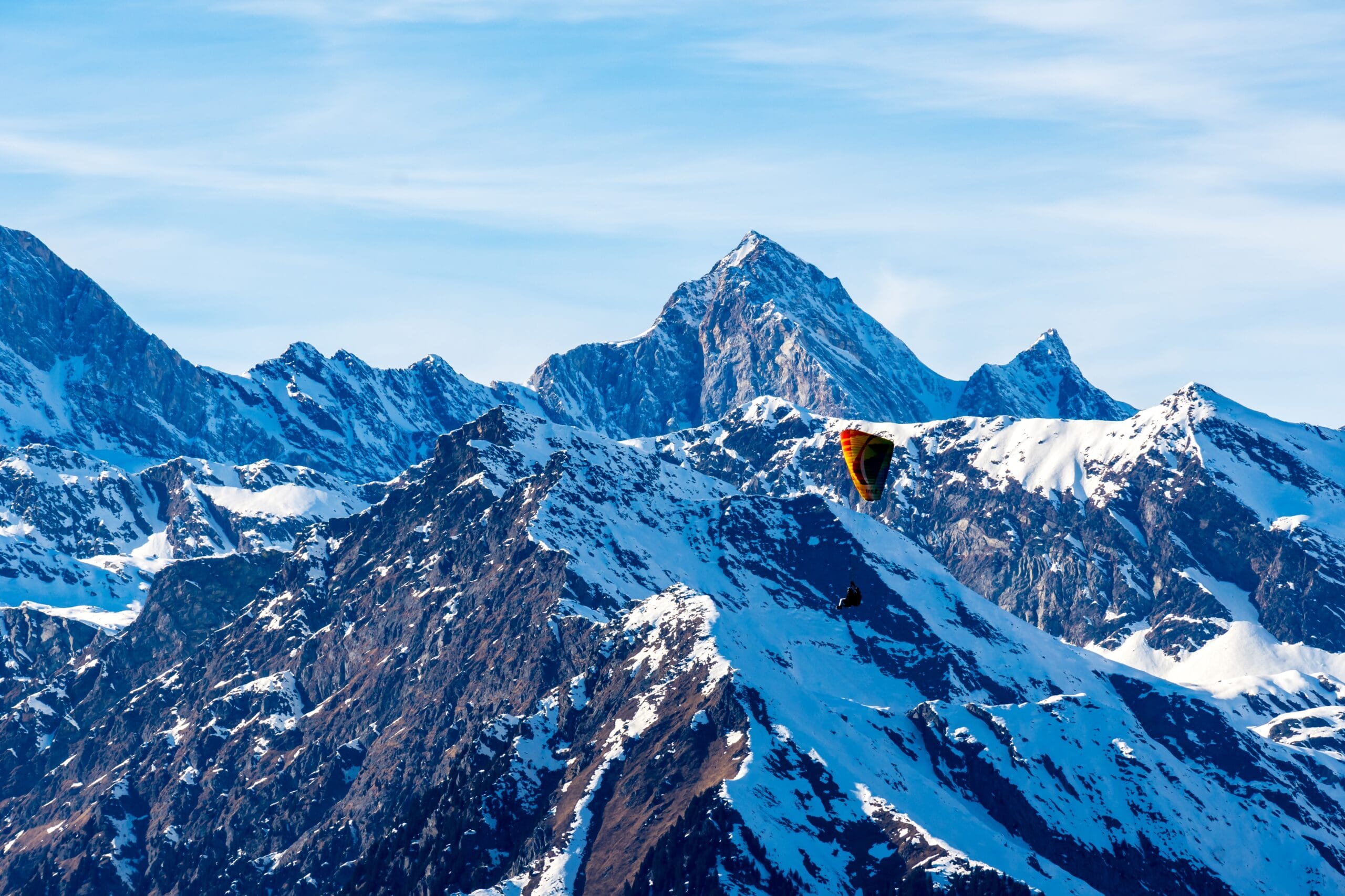 Beautiful landscape of snowcovered mountains with a paraglider in South Tyrol, Dolomites, Italy